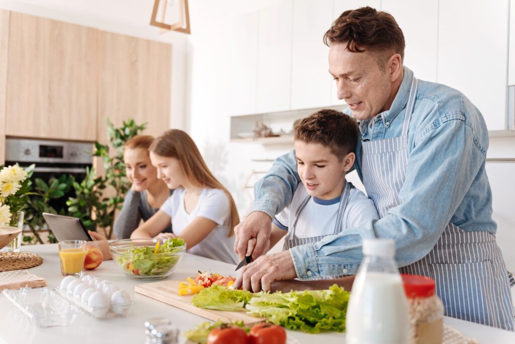 Familie bereitet gemeinsam eine gesunde Mahlzeit zu, symbolisch für die Rolle der Ernährung im Wohlbefinden hochsensibler Menschen.