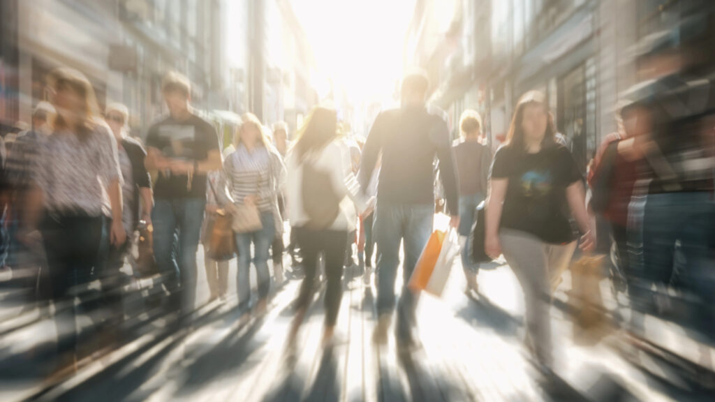 Person fühlt sich überfordert in einer dicht gedrängten Menschenmenge, umgeben von Hektik und Reizen.